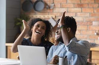 couple high fiving and happy with the outcome of their financial goals